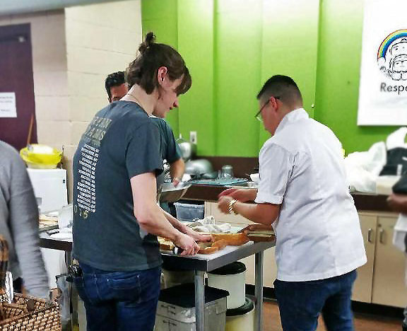 Photo of UNYA's Mentorship Program mentors and youth making a meal together with Chef Heat Leliberte.